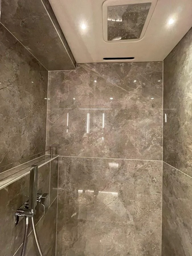 The yacht's bathroom features luxurious marble walls and modern fixtures. aboard SU Yacht for Sale