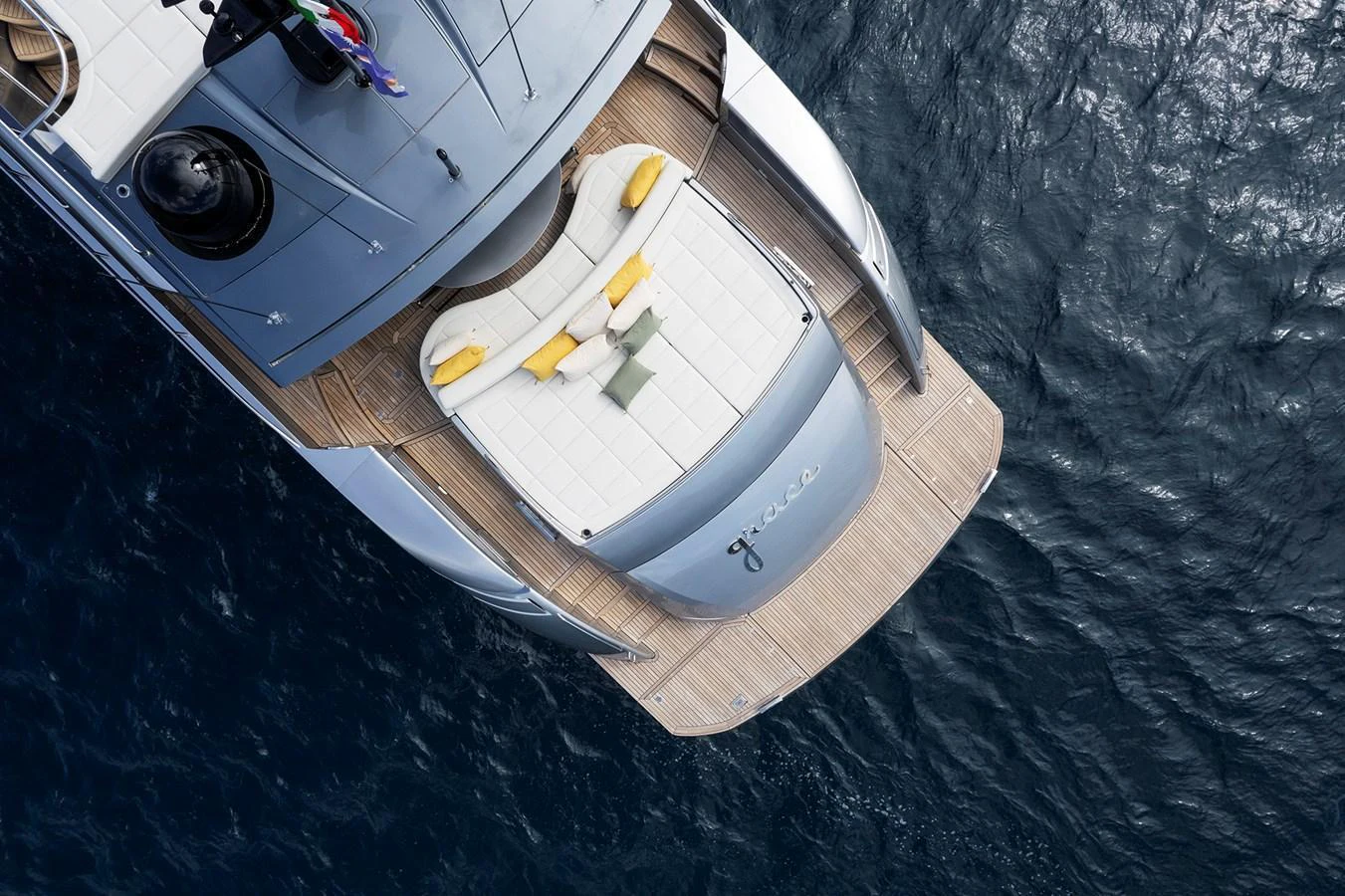 The aft deck of this yacht features a spacious sunbathing area with plush cushions overlooking the serene water. aboard GRACE Yacht for Sale