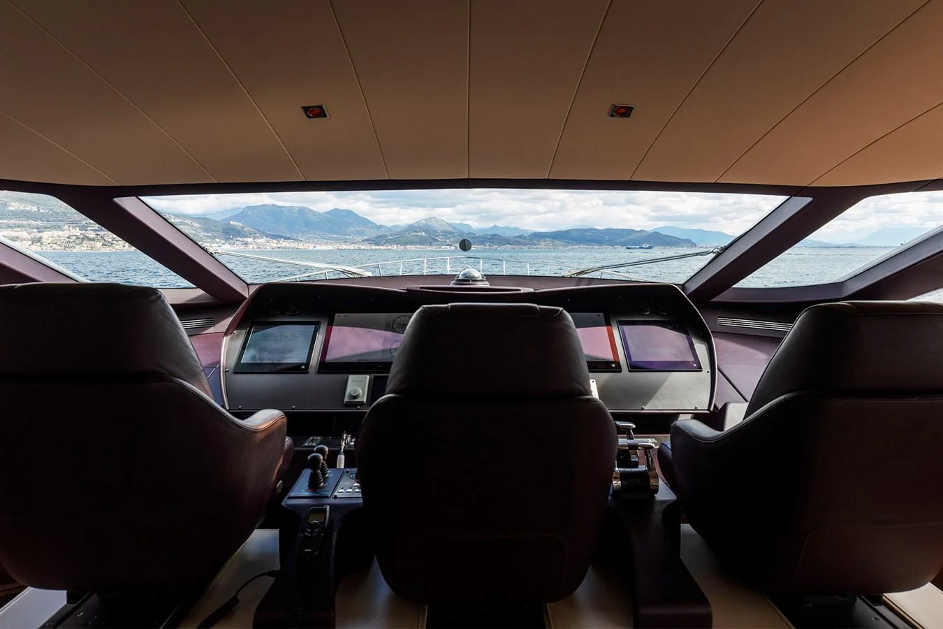 inside of a vehicle with a view of the water and a mountain range aboard GRACE Yacht for Sale