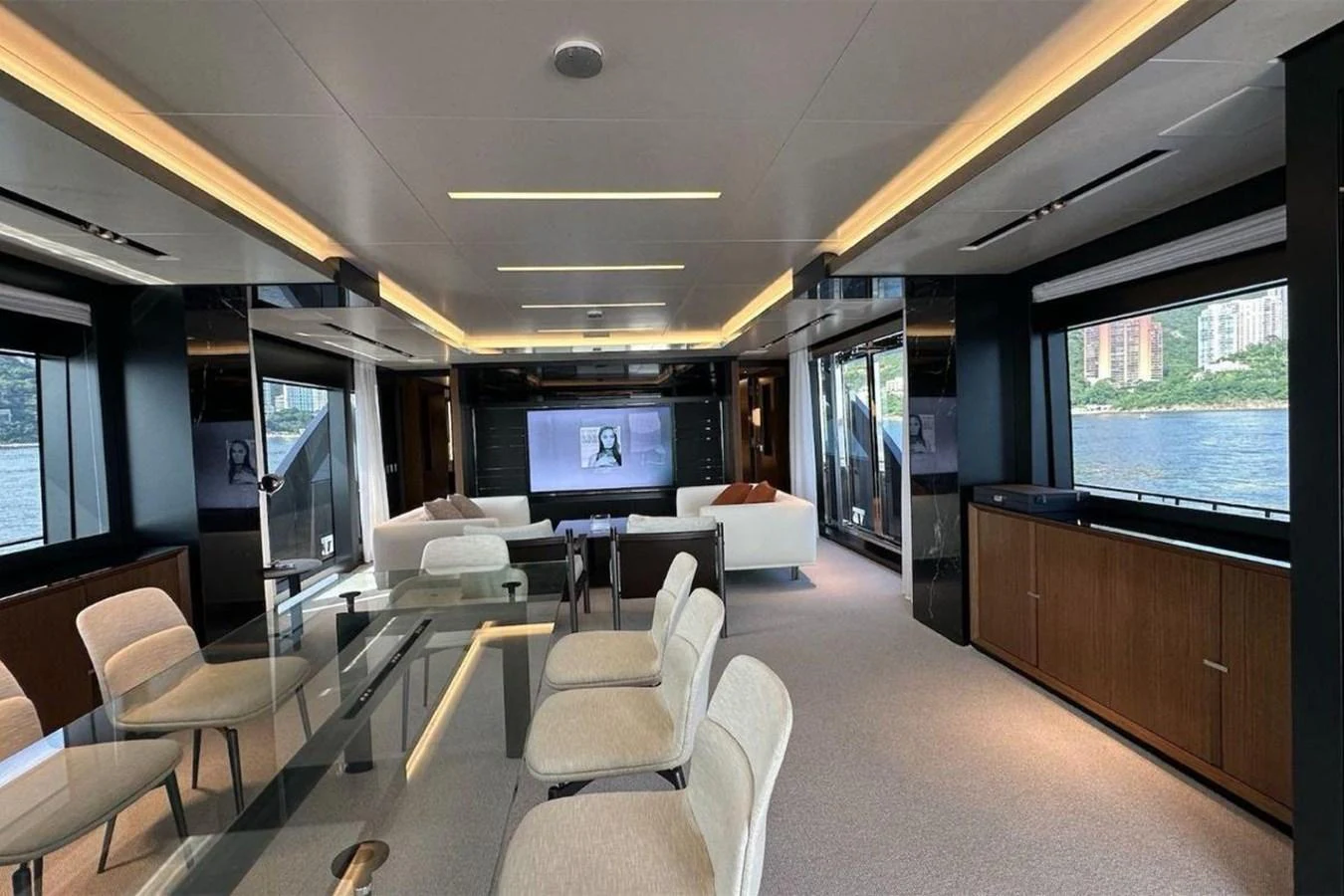 a room with a large window and a large table with chairs and a tv on it aboard BELLA DONNA Yacht for Sale