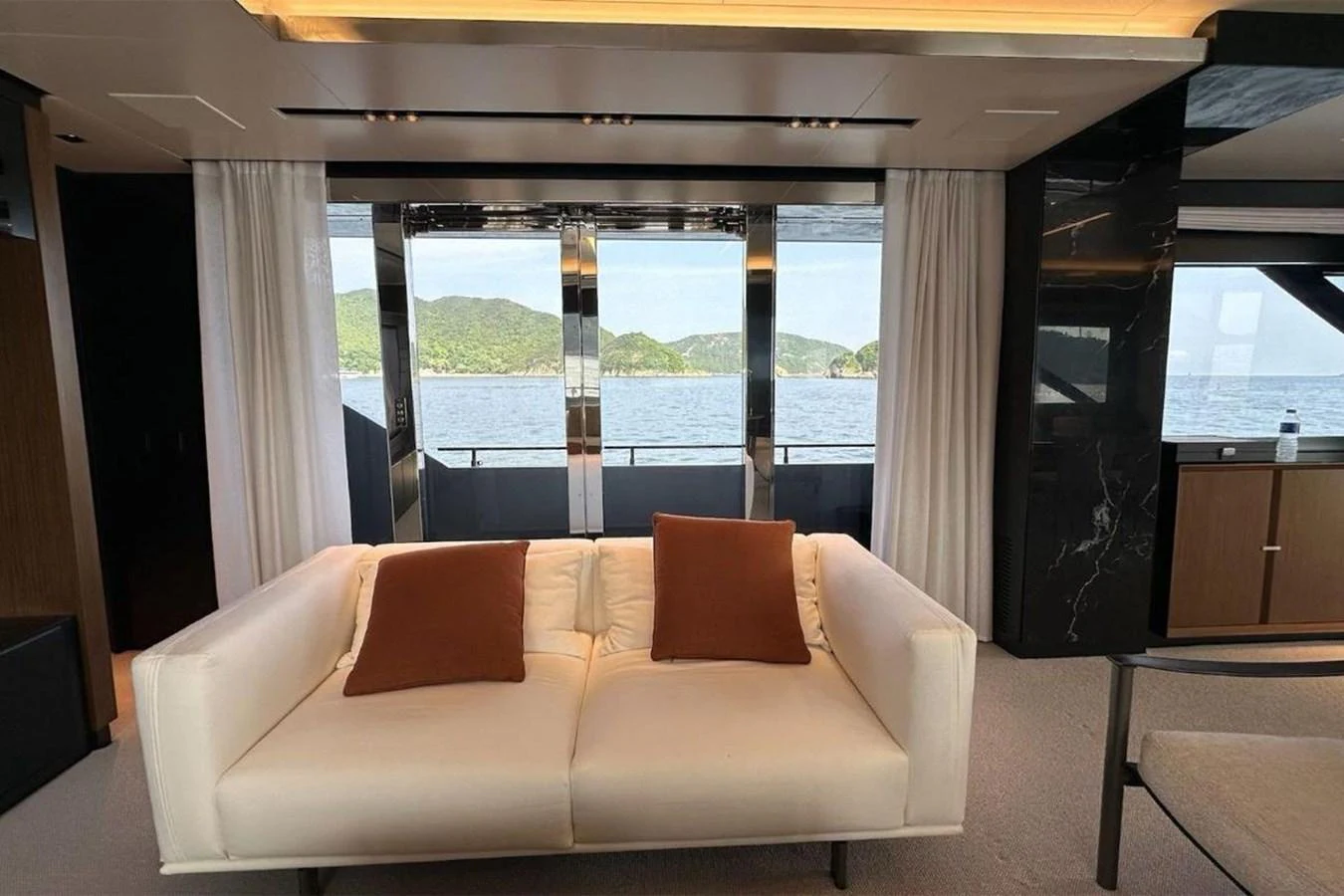 The salon offers a comfortable seating area with a stunning view of the sea through large windows. aboard BELLA DONNA Yacht for Sale