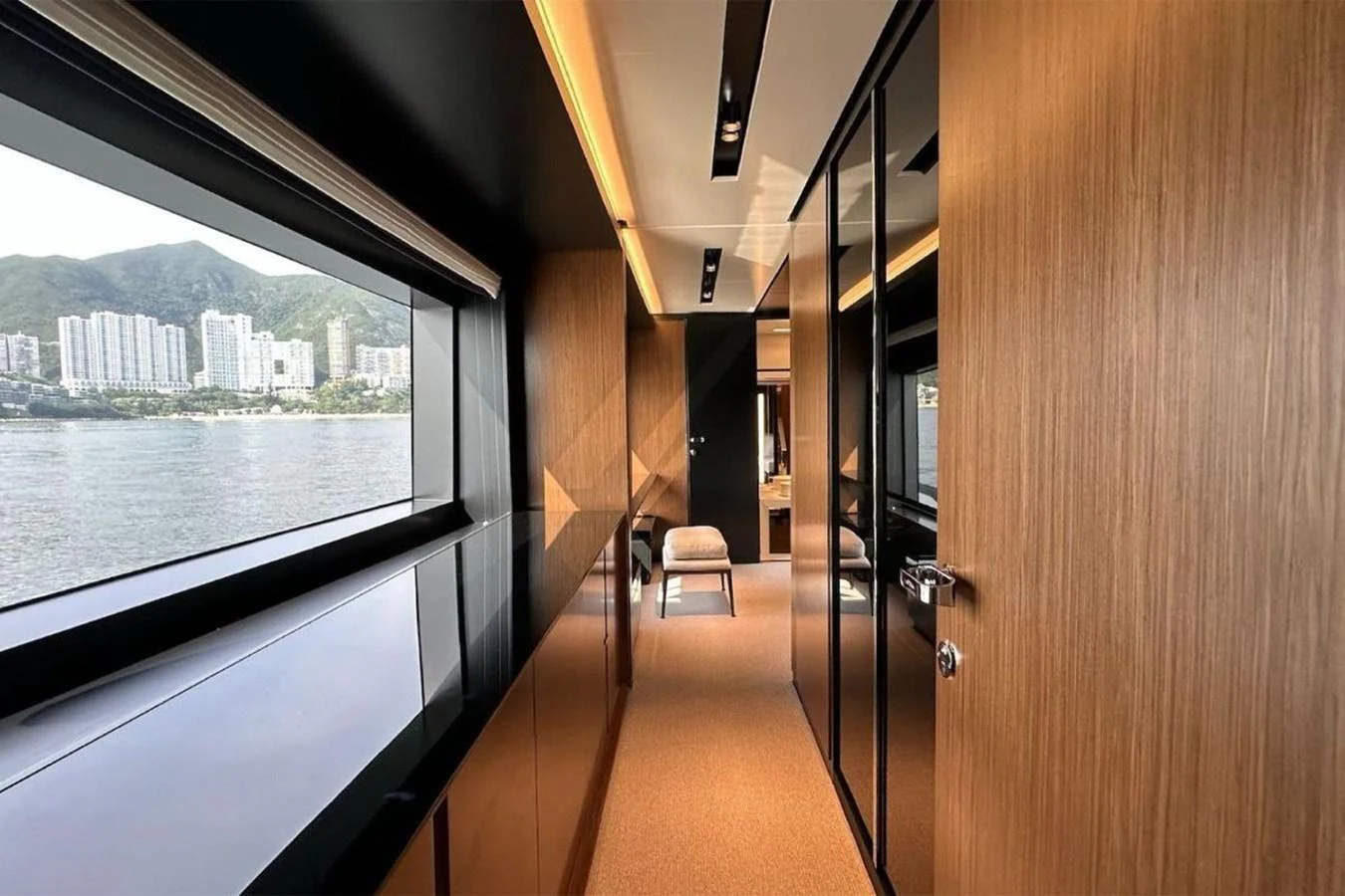 The yacht's interior features a sleek hallway with large windows offering scenic views. aboard BELLA DONNA Yacht for Sale