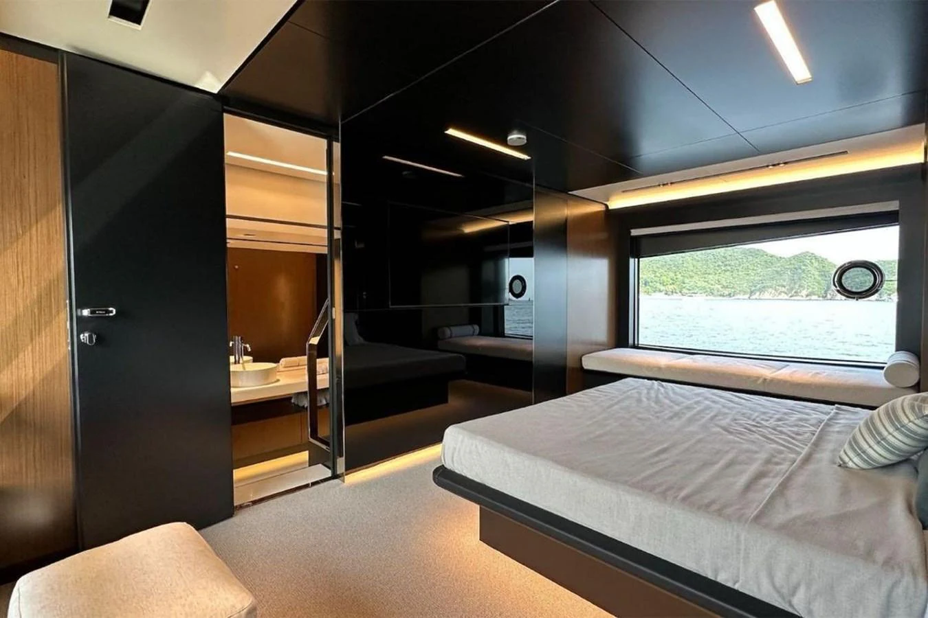 A luxurious stateroom with a large bed, modern decor, and a scenic view through the window. aboard BELLA DONNA Yacht for Sale