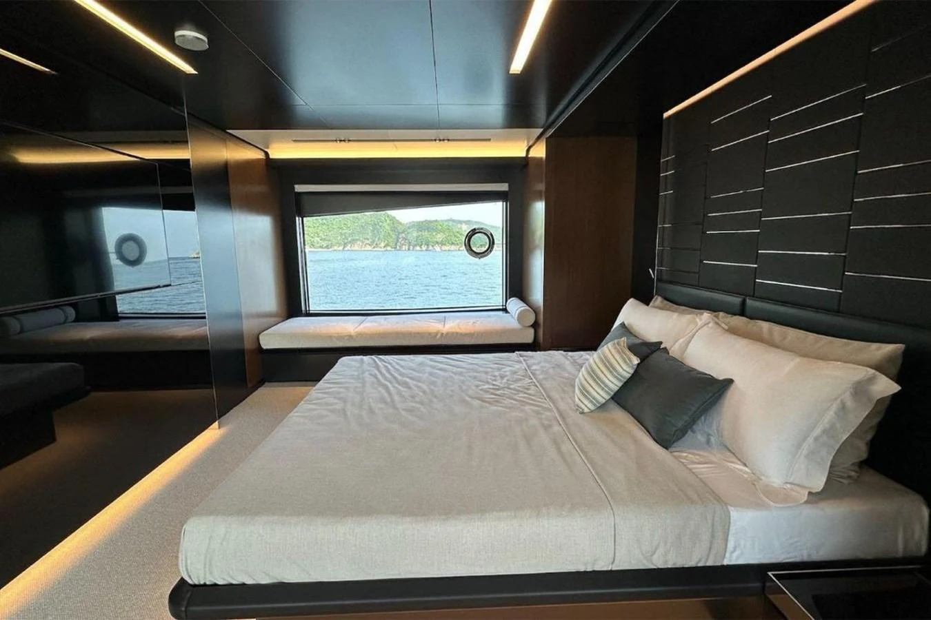 A luxurious stateroom with a large bed and a scenic window view of the sea. aboard BELLA DONNA Yacht for Sale