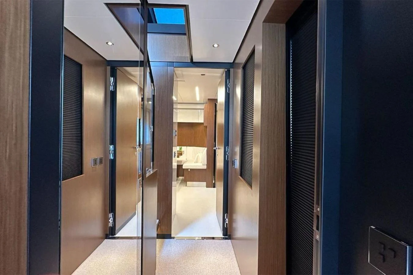 The image showcases a modern yacht interior corridor leading to a well-lit room. aboard BELLA DONNA Yacht for Sale