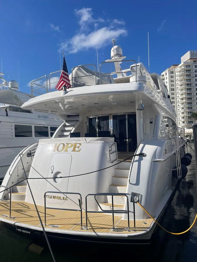 The yacht's aft deck showcases a spacious and inviting area for relaxation and boarding, with a pristine white finish and elegant teak flooring. aboard HOPE Yacht for Sale