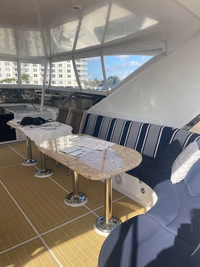 The yacht's salon features a comfortable seating area with striped cushions and a polished table, perfect for relaxation and dining. aboard HOPE Yacht for Sale