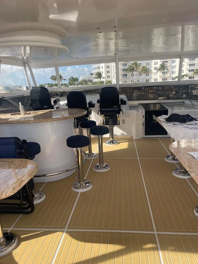 The yacht's helm area features a sleek design with comfortable seating and a polished wooden floor. aboard HOPE Yacht for Sale