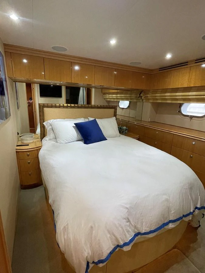 The stateroom features a cozy double bed with elegant wood cabinetry and soft lighting. aboard HOPE Yacht for Sale