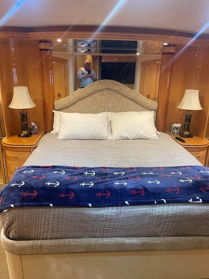 The stateroom features a plush bed with elegant bedding and warm wooden accents, creating a cozy and inviting atmosphere. aboard HOPE Yacht for Sale
