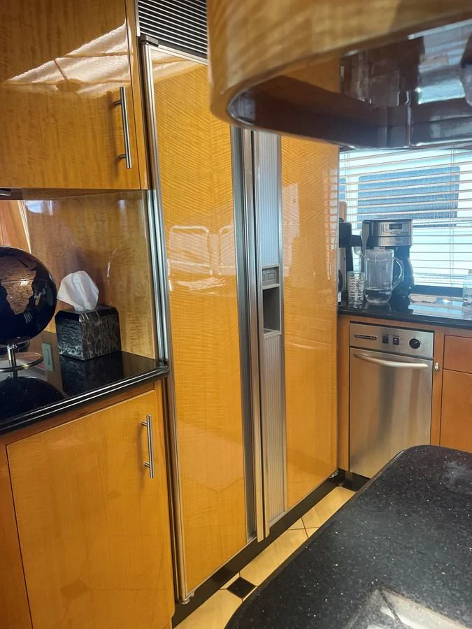 The yacht's galley features high-gloss wood cabinetry, modern appliances, and sleek countertops. aboard HOPE Yacht for Sale