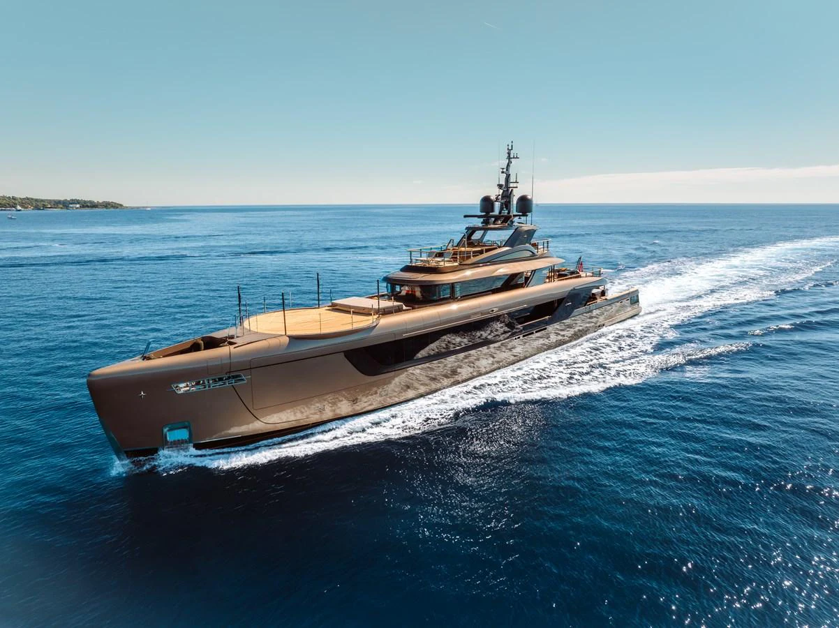 A sleek and modern yacht cruises through the open sea under a clear blue sky. aboard RAJA Yacht for Sale