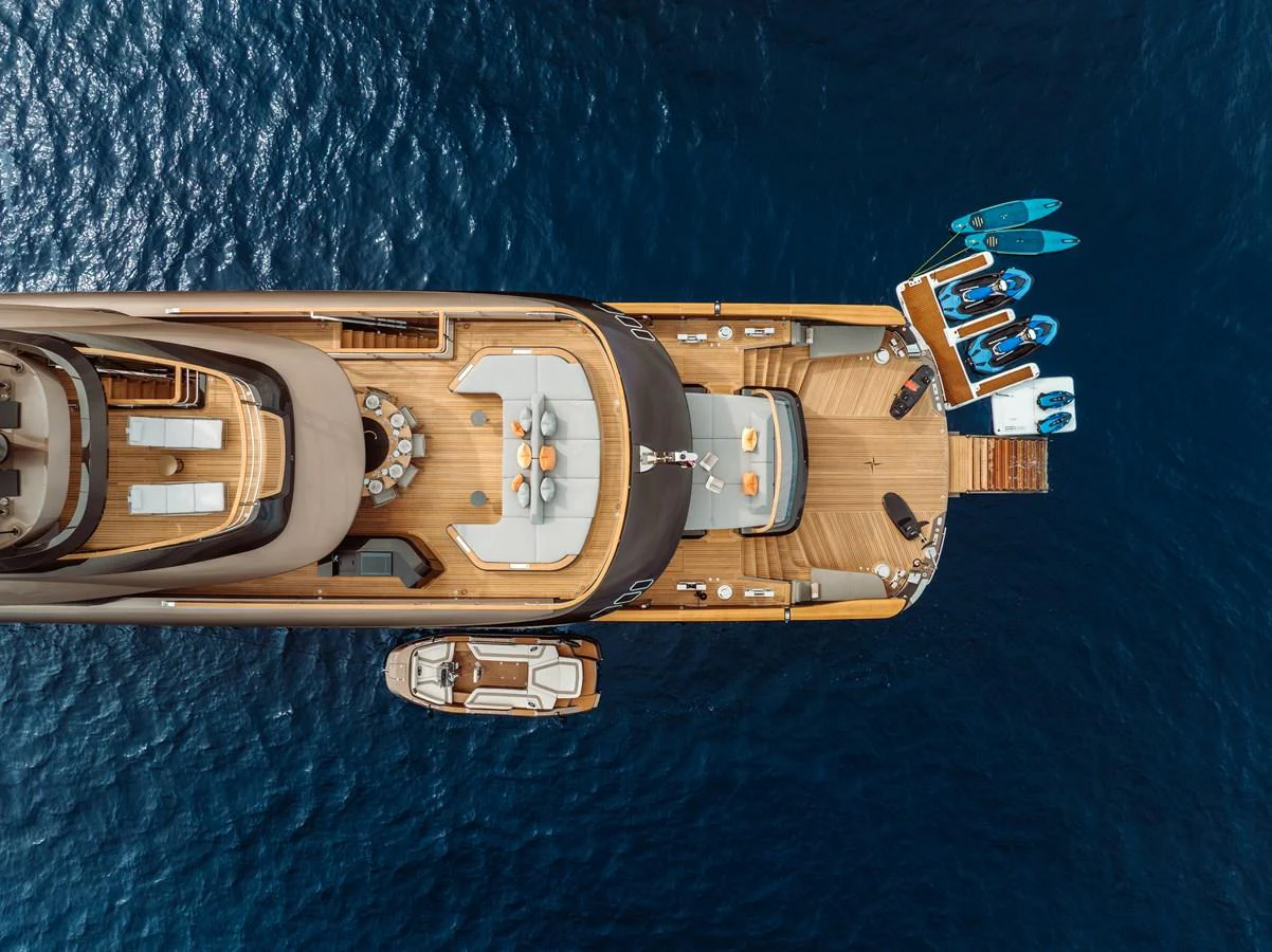 A stunning aerial view of the yacht's aft deck showcasing luxurious seating, dining area, and water toys. aboard RAJA Yacht for Sale