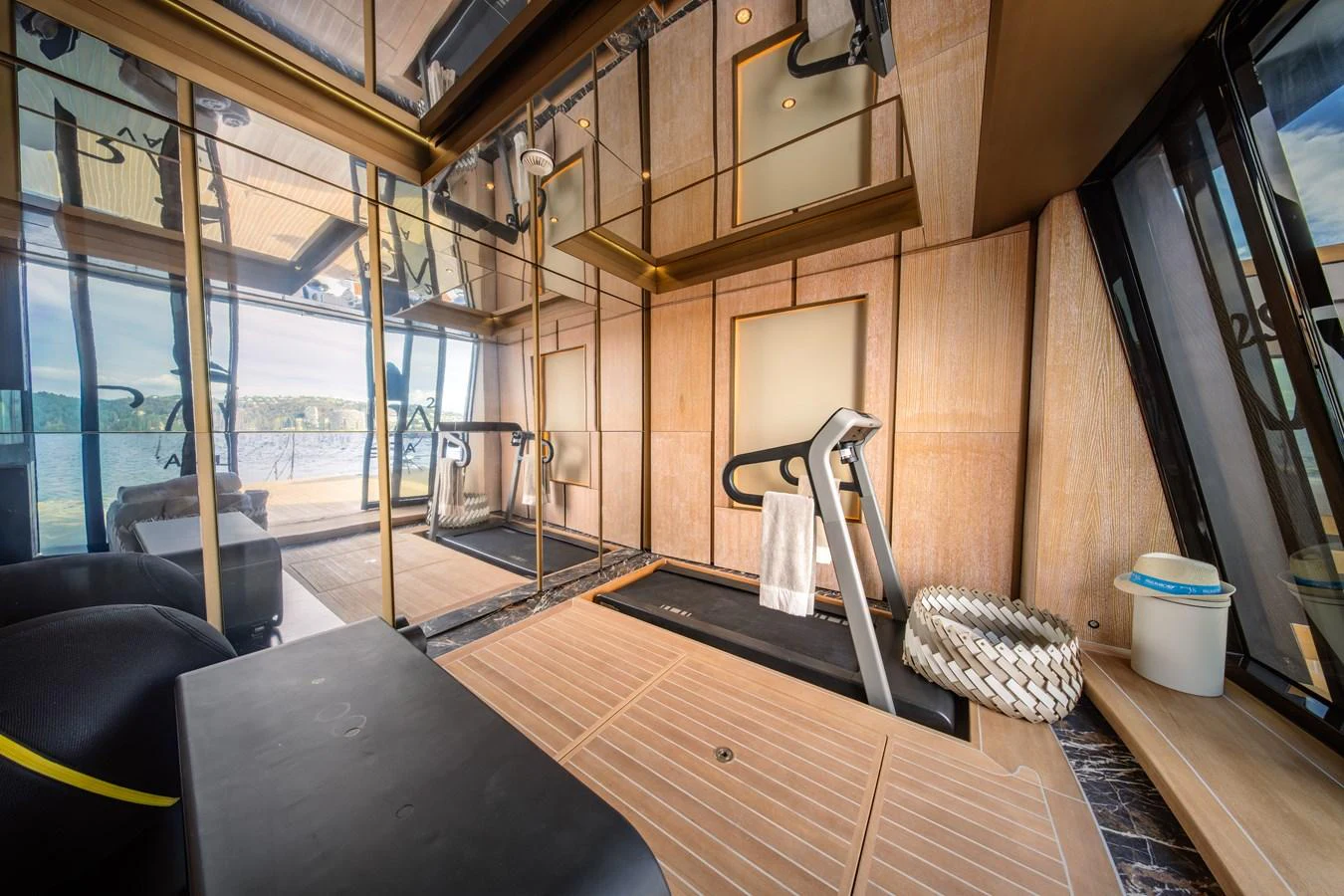 The yacht features a modern gym with a treadmill and mirrored walls, offering a luxurious space for onboard fitness. aboard RAJA Yacht for Sale