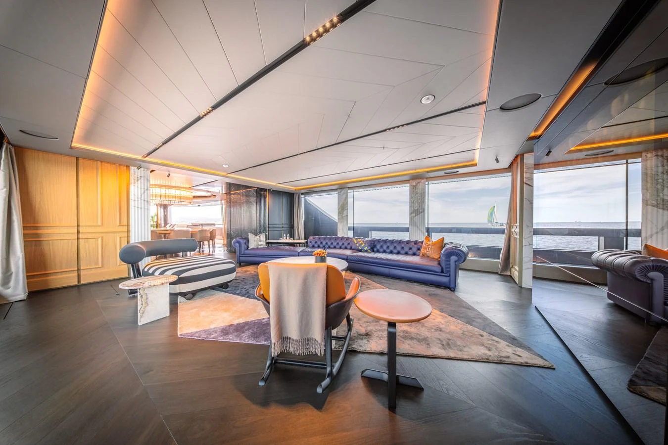 The yacht's salon features luxurious seating with panoramic ocean views through large windows. aboard RAJA Yacht for Sale