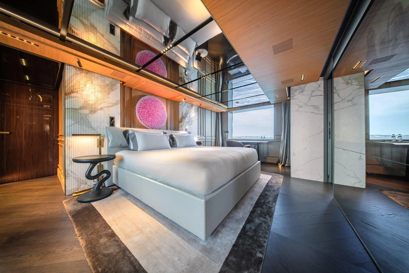 The master stateroom exudes luxury with its modern design, featuring a plush bed, elegant decor, and expansive windows offering stunning sea views. aboard RAJA Yacht for Sale