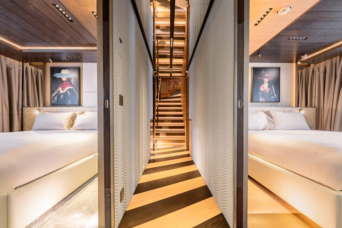 A luxurious hallway with elegant lighting and two adjacent staterooms featuring modern decor. aboard RAJA Yacht for Sale