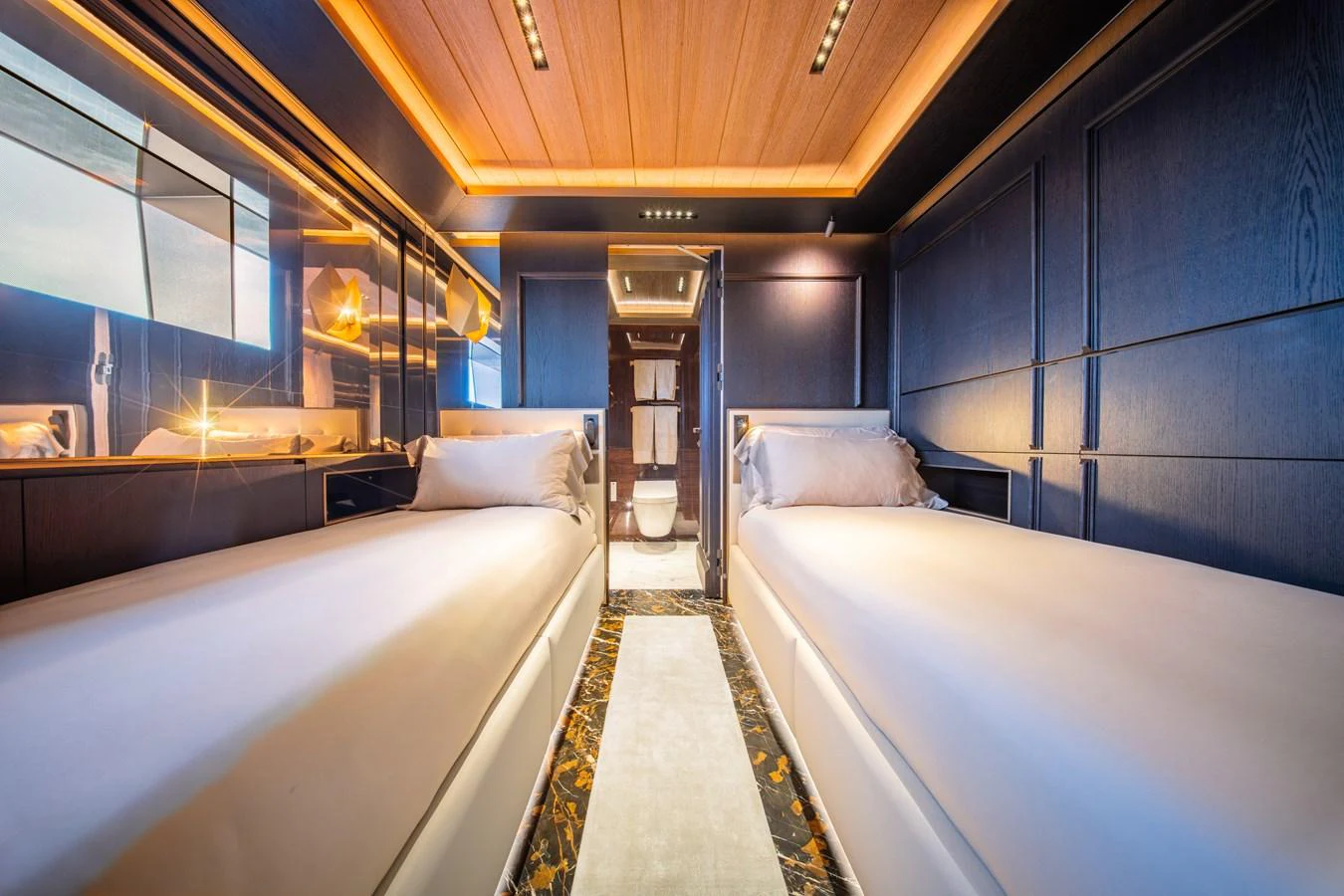 The twin stateroom features sleek, modern design with luxurious finishes and ambient lighting. aboard RAJA Yacht for Sale