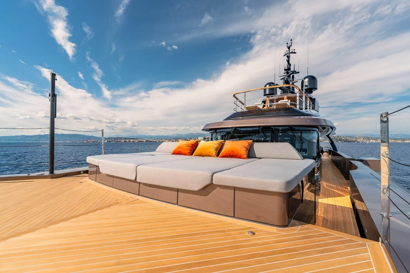 The yacht's foredeck features a spacious sunbathing area with plush cushions and vibrant accent pillows. aboard RAJA Yacht for Sale