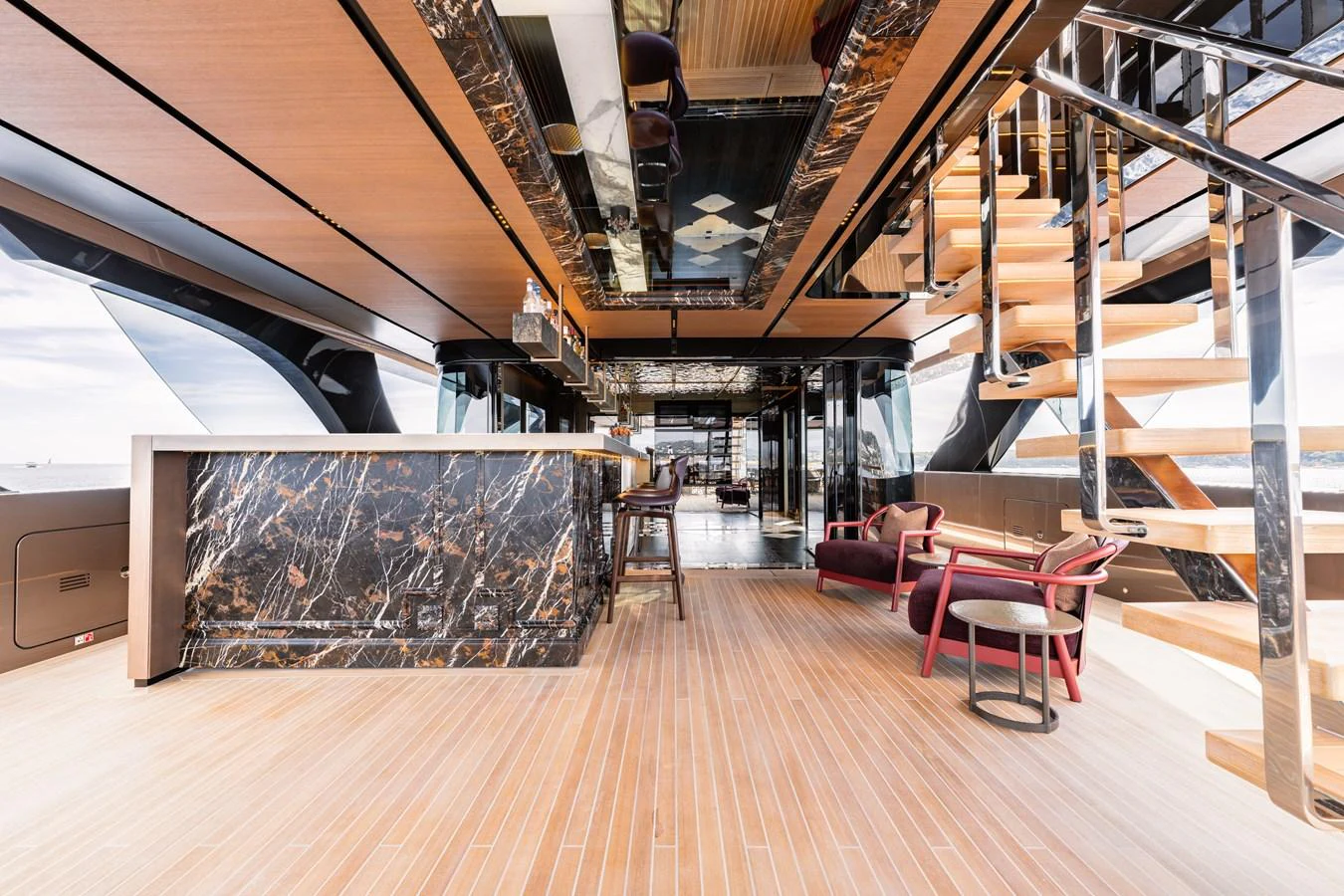 The main deck features a luxurious bar area with elegant seating and a modern staircase. aboard RAJA Yacht for Sale