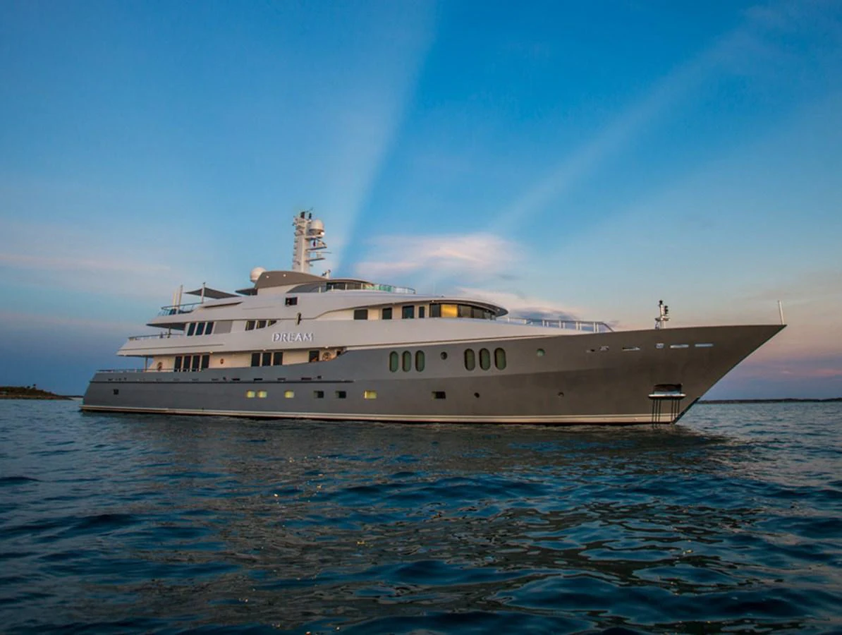 A stunning yacht glides gracefully on calm waters under a serene evening sky. aboard DREAM Yacht for Sale