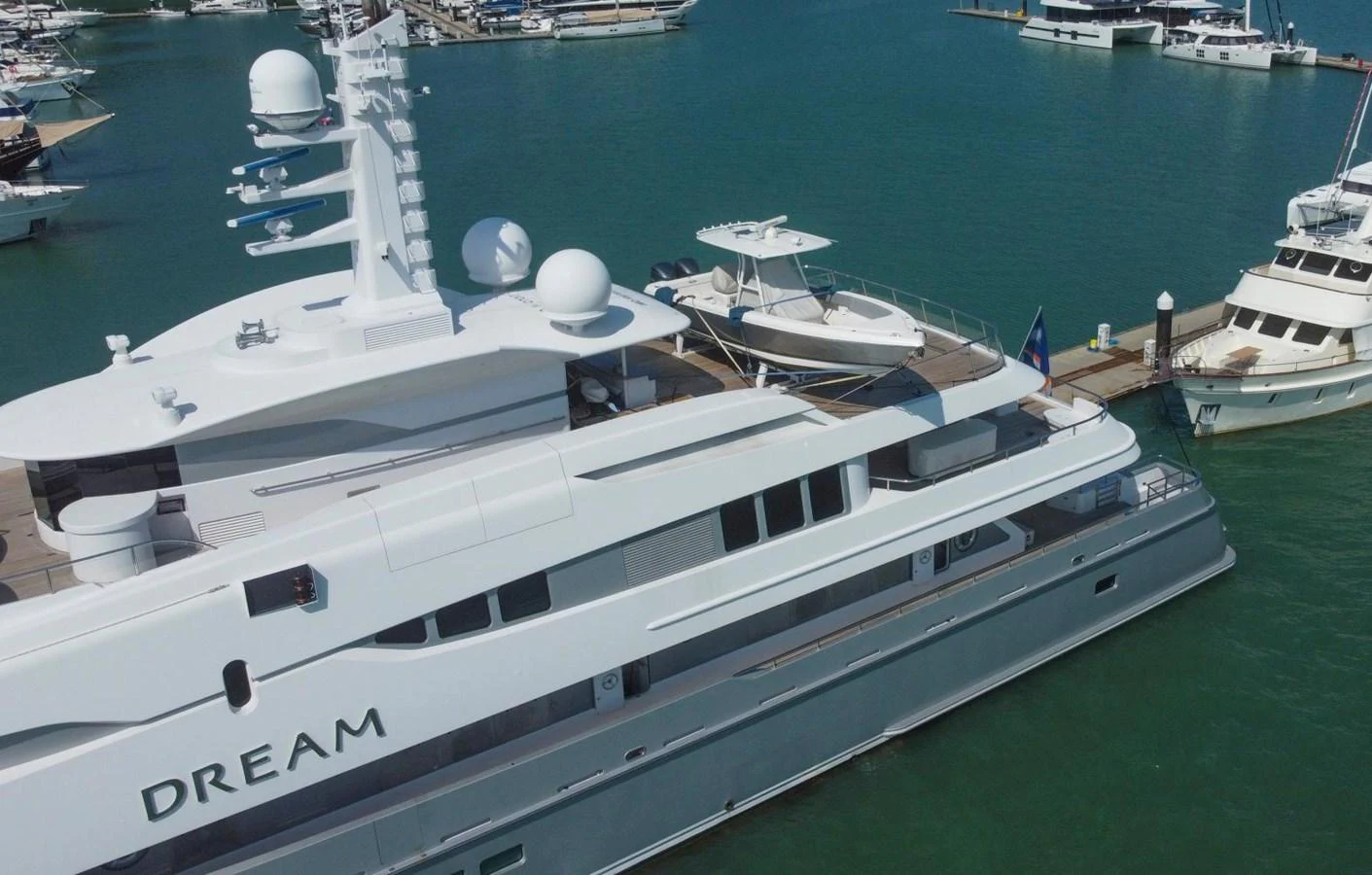 A luxurious yacht docked at a marina, showcasing its sleek design and modern amenities. aboard DREAM Yacht for Sale