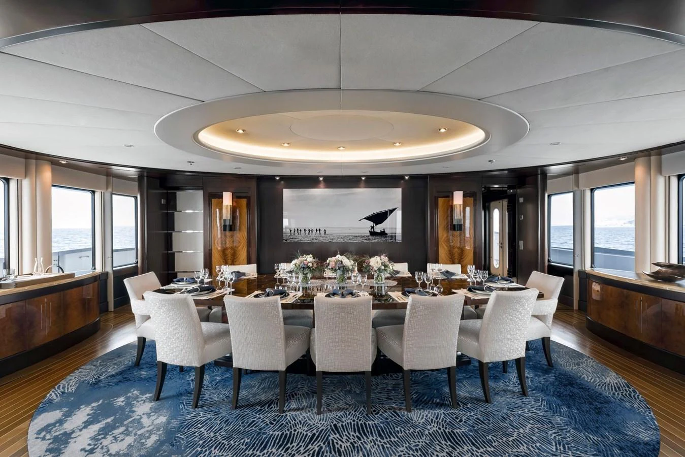 The yacht's dining area features an elegant table setting with panoramic ocean views. aboard DREAM Yacht for Sale
