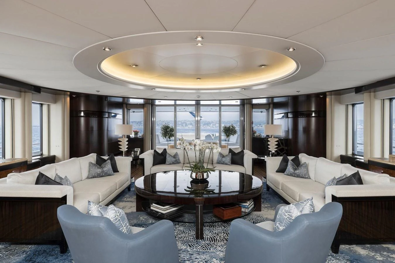 The salon features elegant seating with panoramic views through large windows. aboard DREAM Yacht for Sale