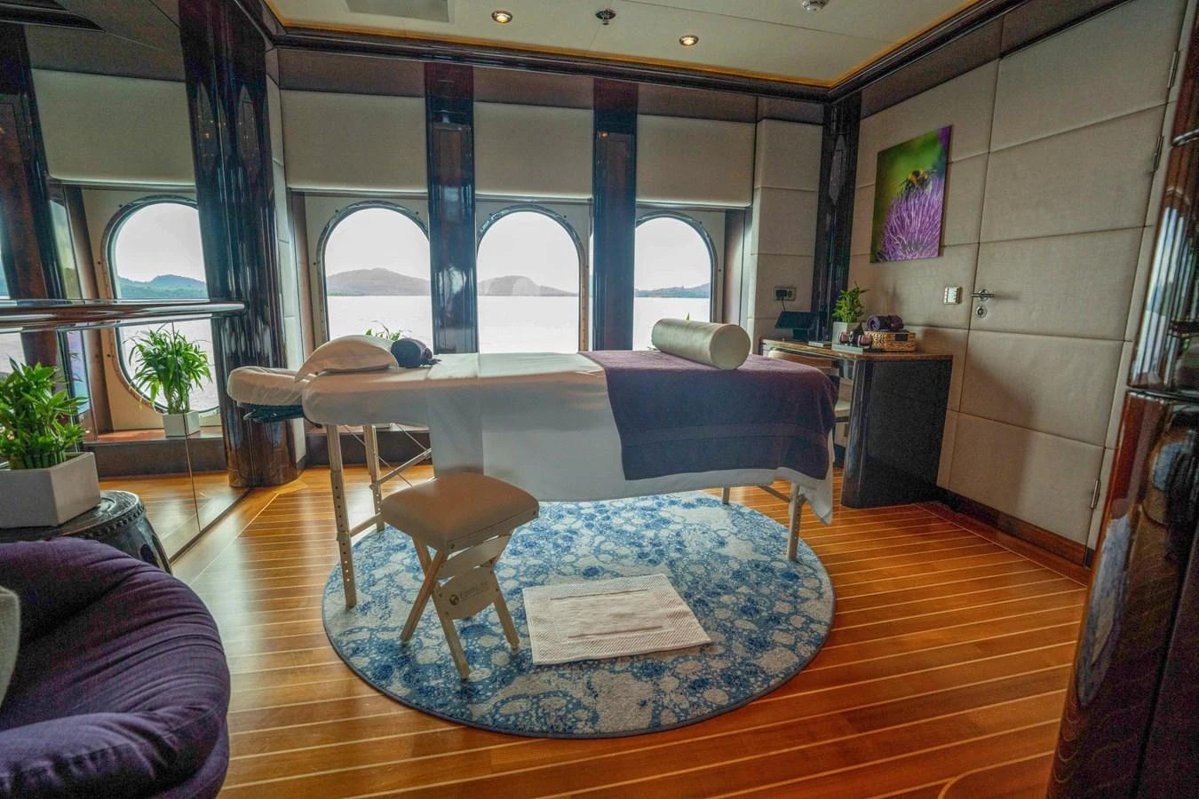 The yacht's spa room offers a serene space with a massage table and panoramic ocean views. aboard DREAM Yacht for Sale