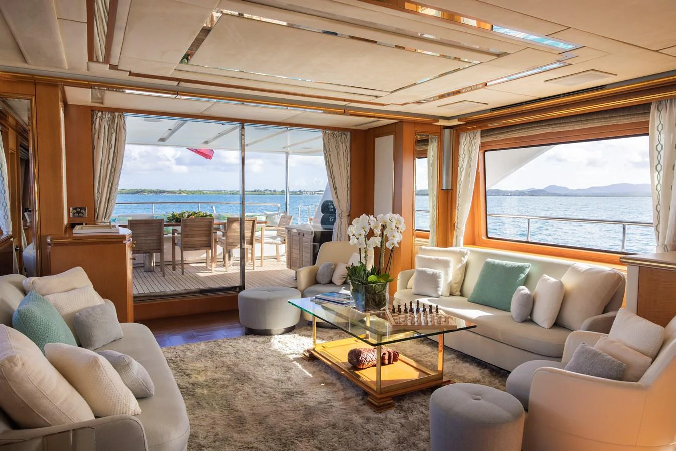 The salon offers a luxurious and comfortable space with plush seating, elegant decor, and a stunning view of the sea through large windows. aboard SEA GYPSY Yacht for Sale