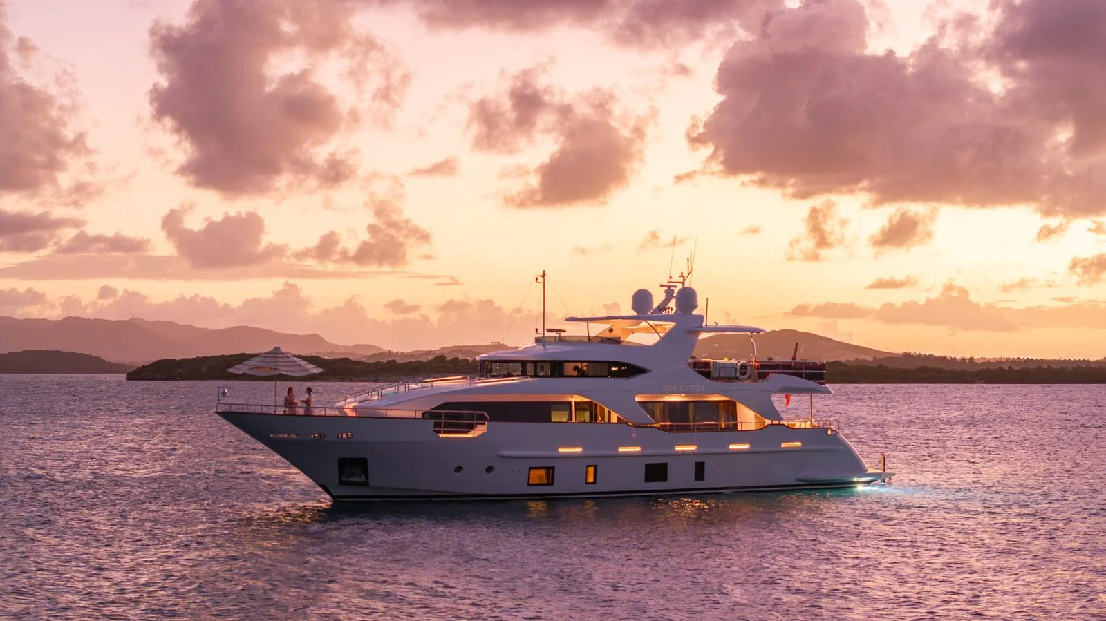 A luxurious yacht cruises serenely at sunset, showcasing its elegant design and inviting ambiance. aboard SEA GYPSY Yacht for Sale