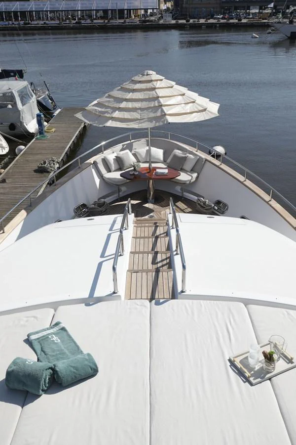 The foredeck features a spacious sunbathing area with plush cushions and a shaded seating area perfect for relaxation. aboard SEA GYPSY Yacht for Sale