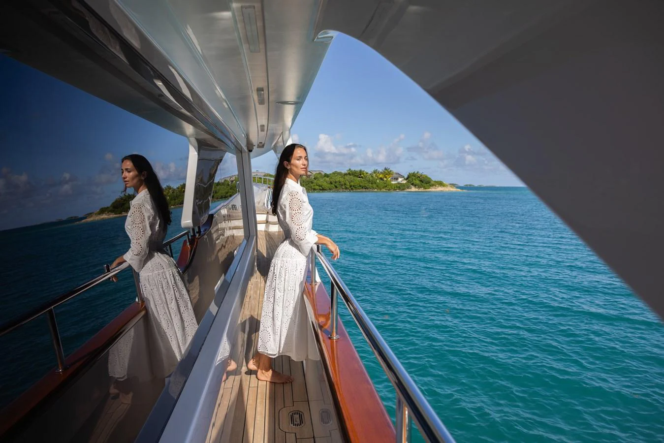 A serene moment on the side deck of a yacht, with a woman enjoying the scenic ocean view. aboard SEA GYPSY Yacht for Sale