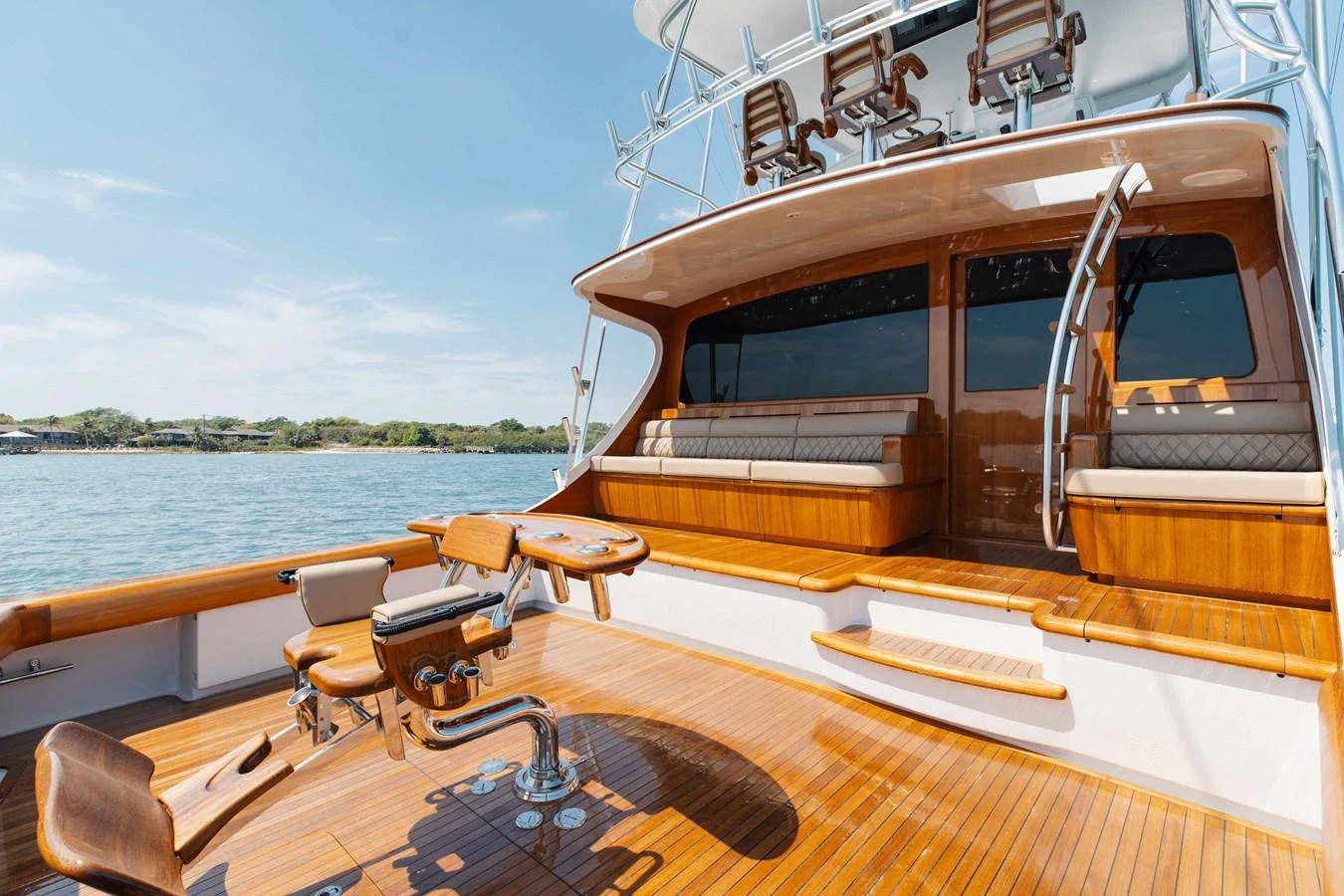 The yacht's aft deck features luxurious seating and a fishing chair, perfect for relaxation and sport. aboard QUEEN BEE Yacht for Sale