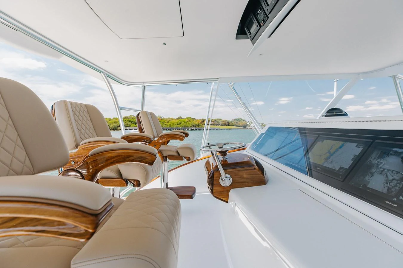 The helm features luxurious seating and state-of-the-art navigation equipment with a panoramic view. aboard QUEEN BEE Yacht for Sale