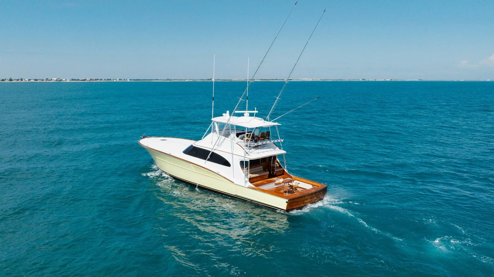A sleek yacht cruises through clear blue waters under a bright sky. aboard QUEEN BEE Yacht for Sale