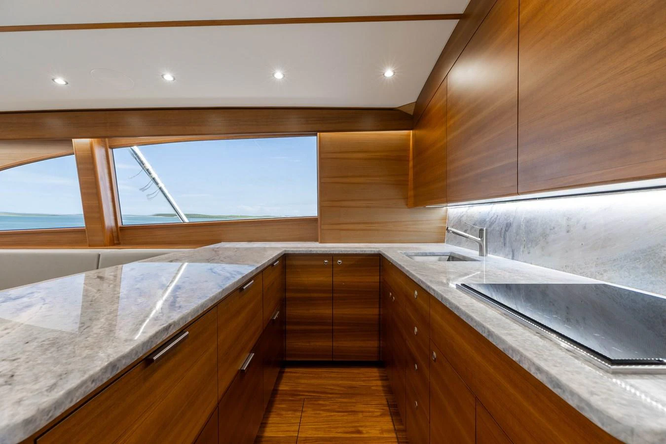 The galley features sleek wooden cabinetry and modern appliances, offering a stylish and functional space for meal preparation. aboard QUEEN BEE Yacht for Sale