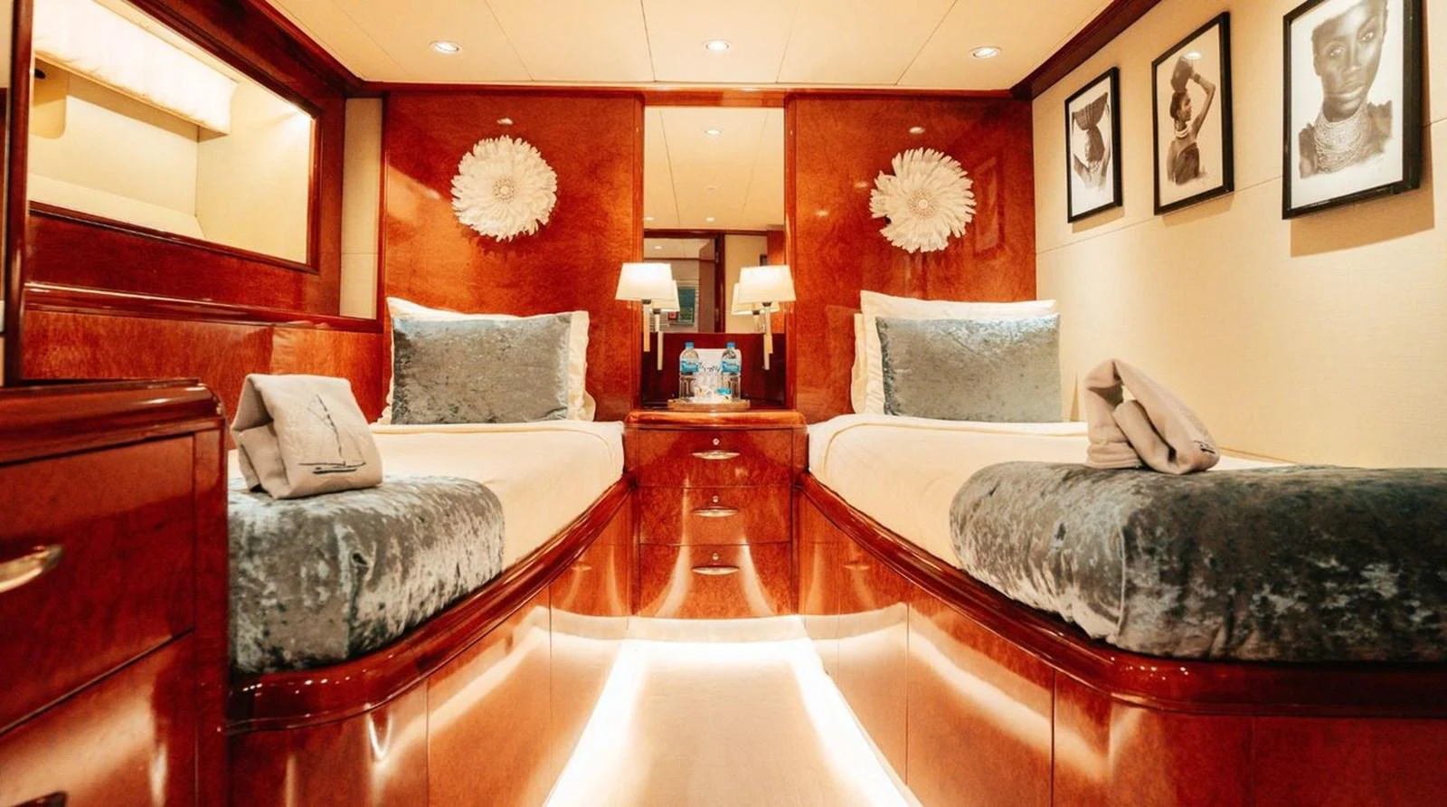 The twin stateroom features luxurious bedding and elegant wood finishes, creating a cozy and inviting atmosphere. aboard THANDEKA Yacht for Sale