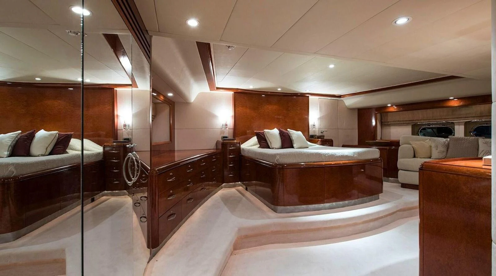 The master stateroom features a luxurious bed with elegant wood finishes and ample lighting. aboard THANDEKA Yacht for Sale