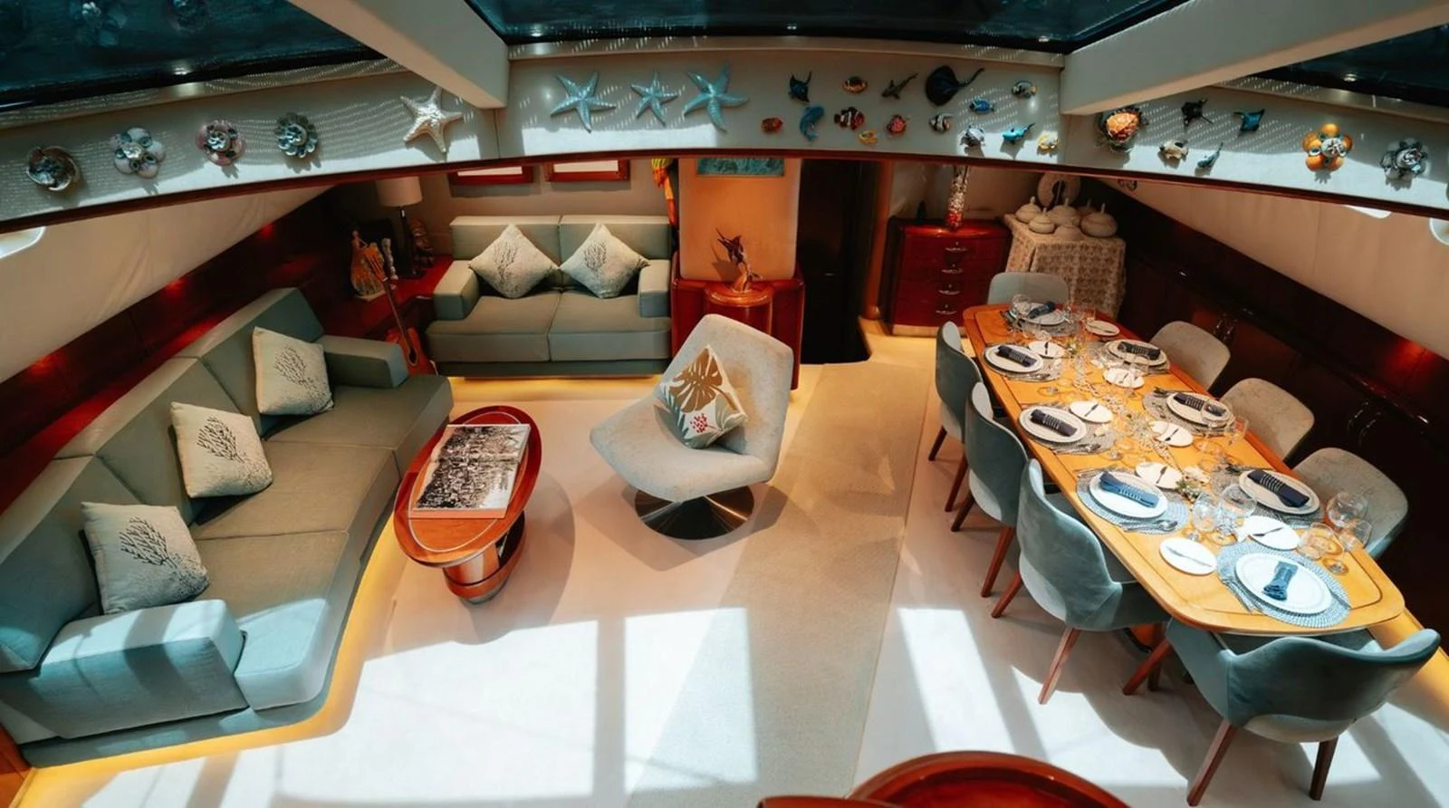 The yacht's salon features a cozy seating area and an elegant dining table, creating a welcoming and luxurious atmosphere. aboard THANDEKA Yacht for Sale