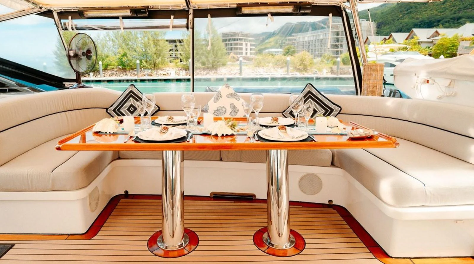 The yacht's dining area features a stylish table set for a meal, surrounded by comfortable seating with scenic views. aboard THANDEKA Yacht for Sale