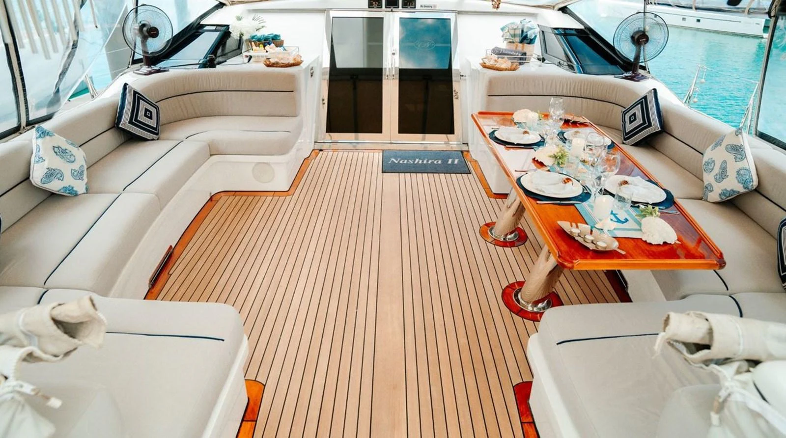 The aft deck features elegant seating and a beautifully set dining table, perfect for alfresco dining. aboard THANDEKA Yacht for Sale