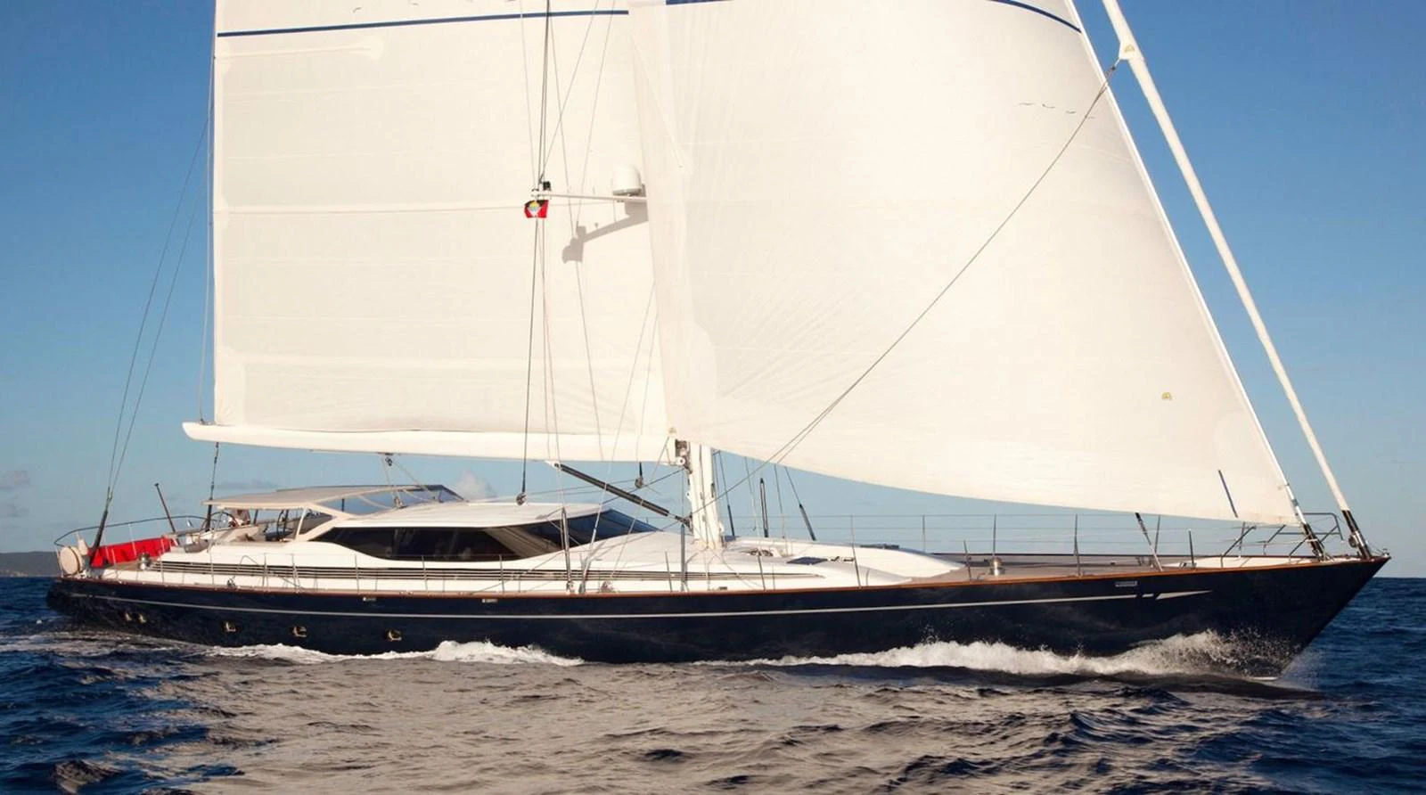 A sleek sailing yacht glides gracefully over the water under full sail. aboard THANDEKA Yacht for Sale