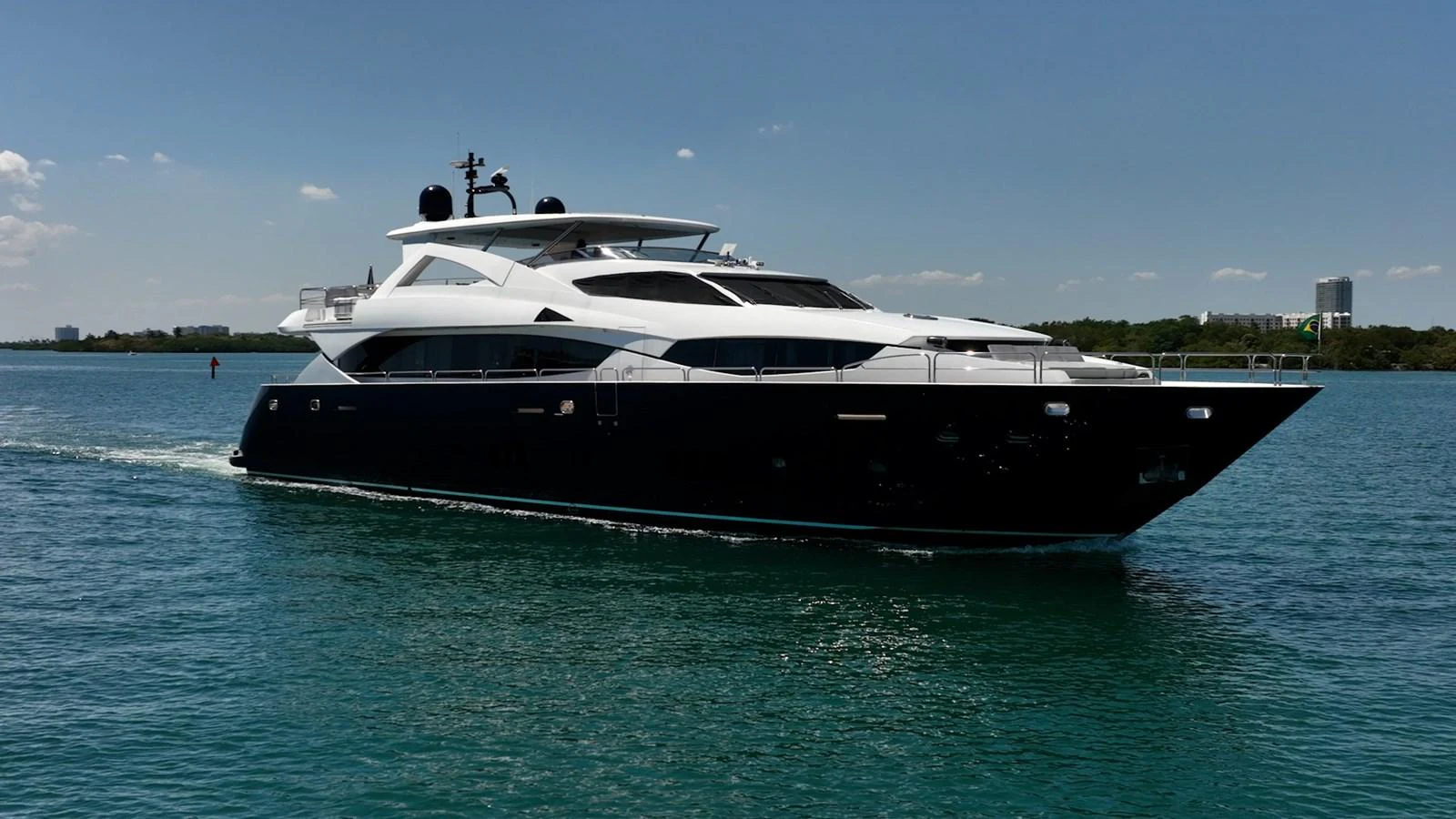 A sleek and modern yacht cruising on calm waters under a clear blue sky. aboard BLUE Yacht for Sale