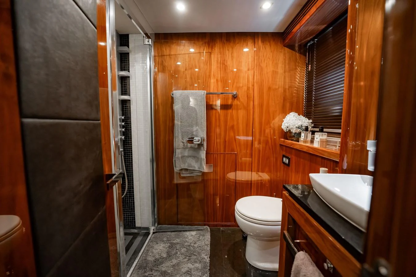 The yacht's bathroom features luxurious wood paneling and modern fixtures. aboard BLUE Yacht for Sale