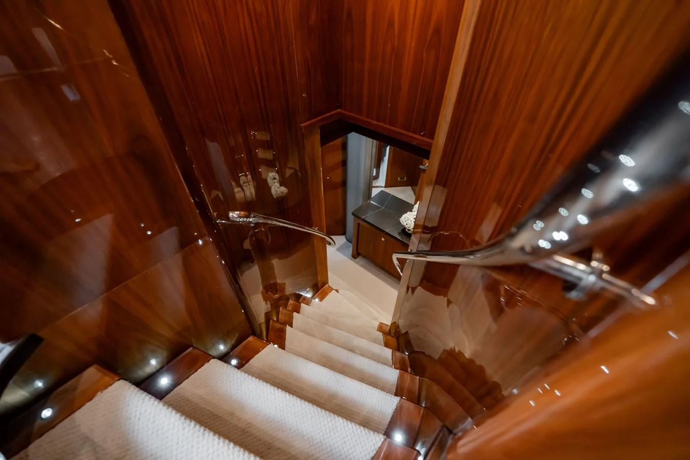 A luxurious staircase with polished wood paneling leads to the lower deck. aboard BLUE Yacht for Sale