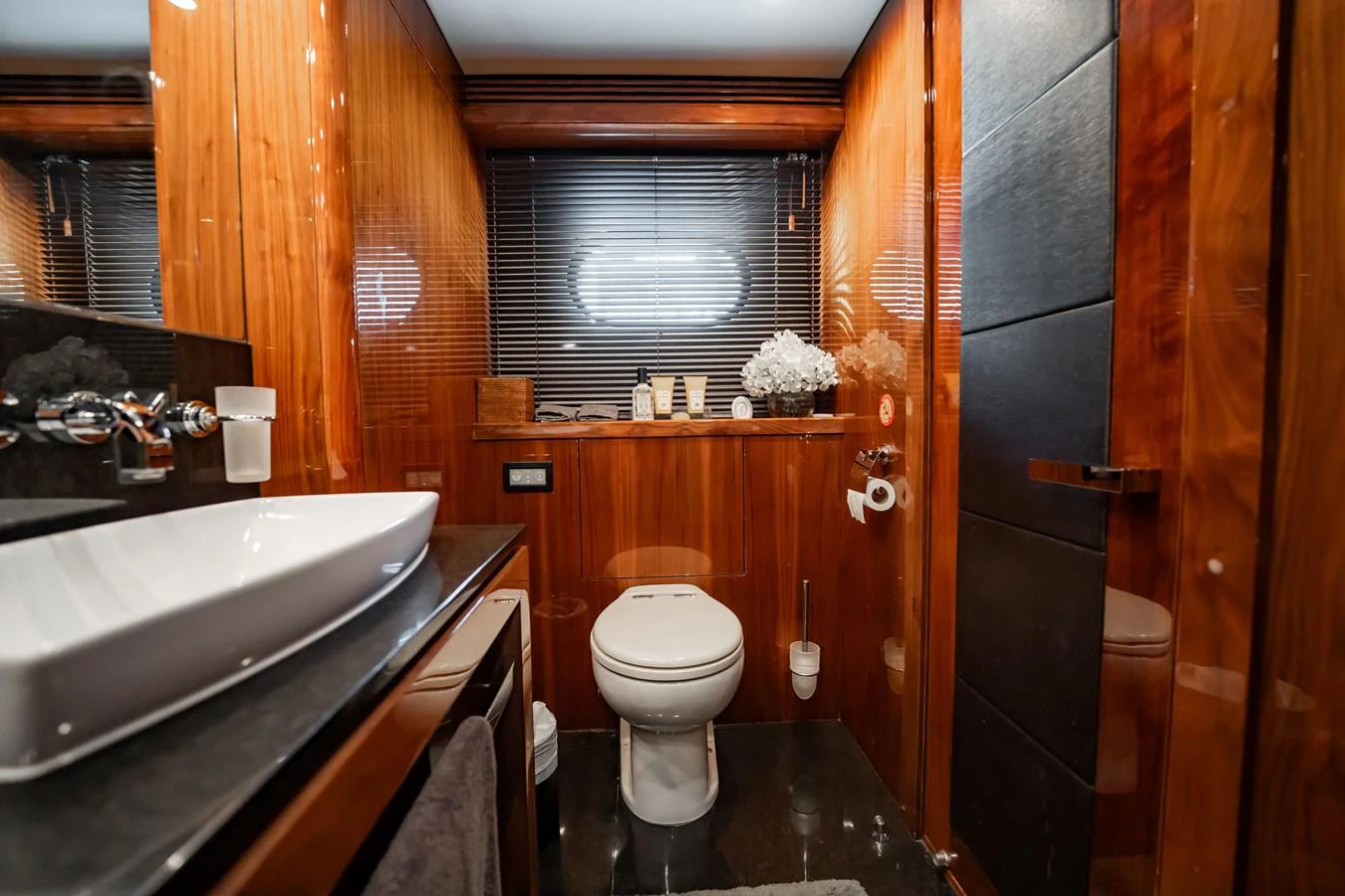 The yacht's bathroom features elegant wood paneling and modern fixtures. aboard BLUE Yacht for Sale