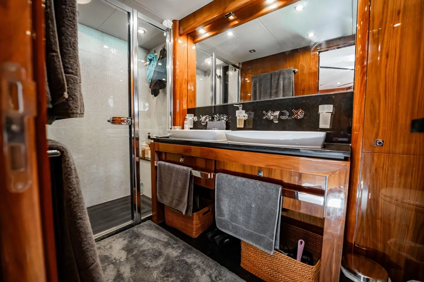 The yacht's bathroom features elegant wooden cabinetry and a spacious shower area. aboard BLUE Yacht for Sale