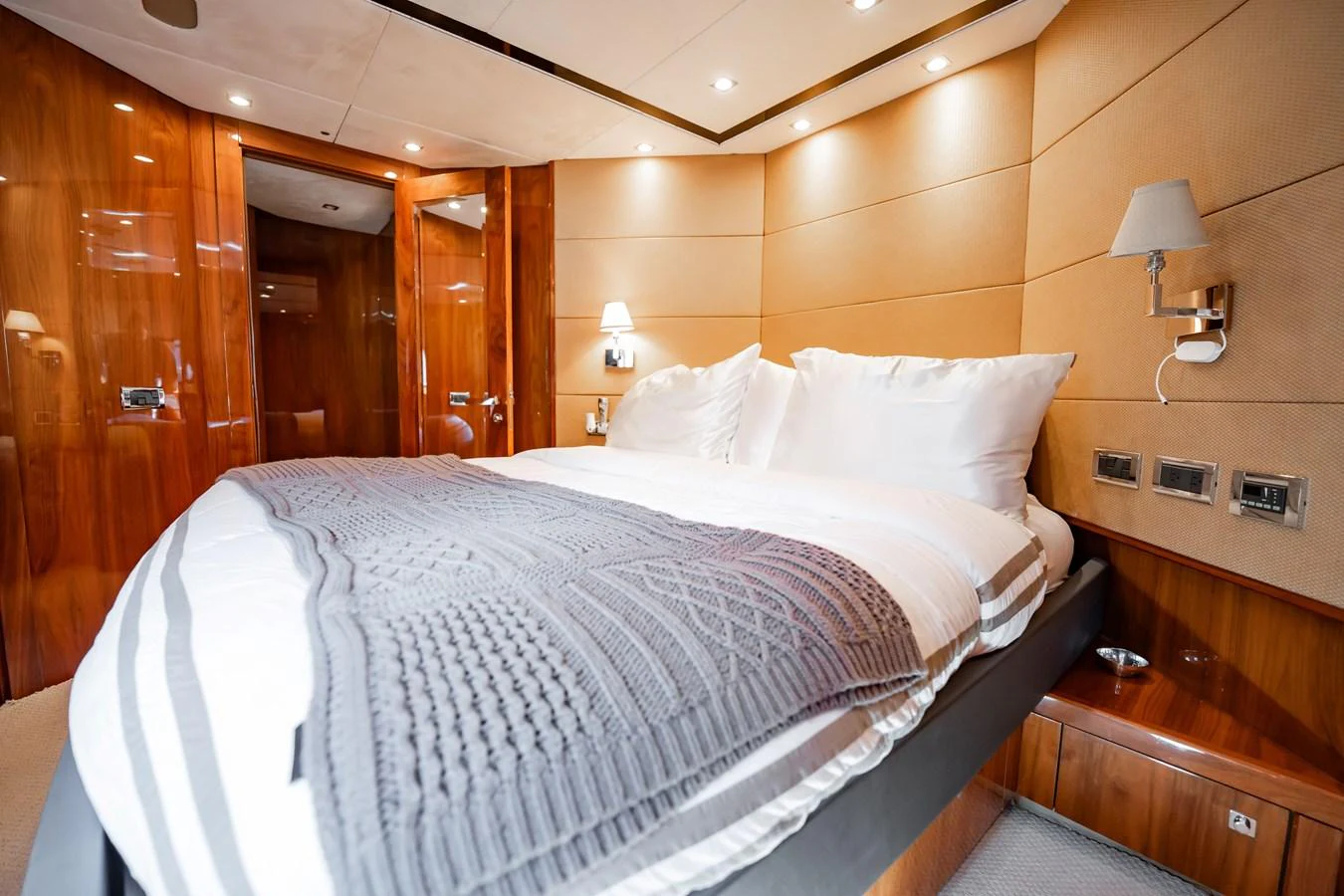 The stateroom features a luxurious bed with plush linens and elegant wood paneling. aboard BLUE Yacht for Sale