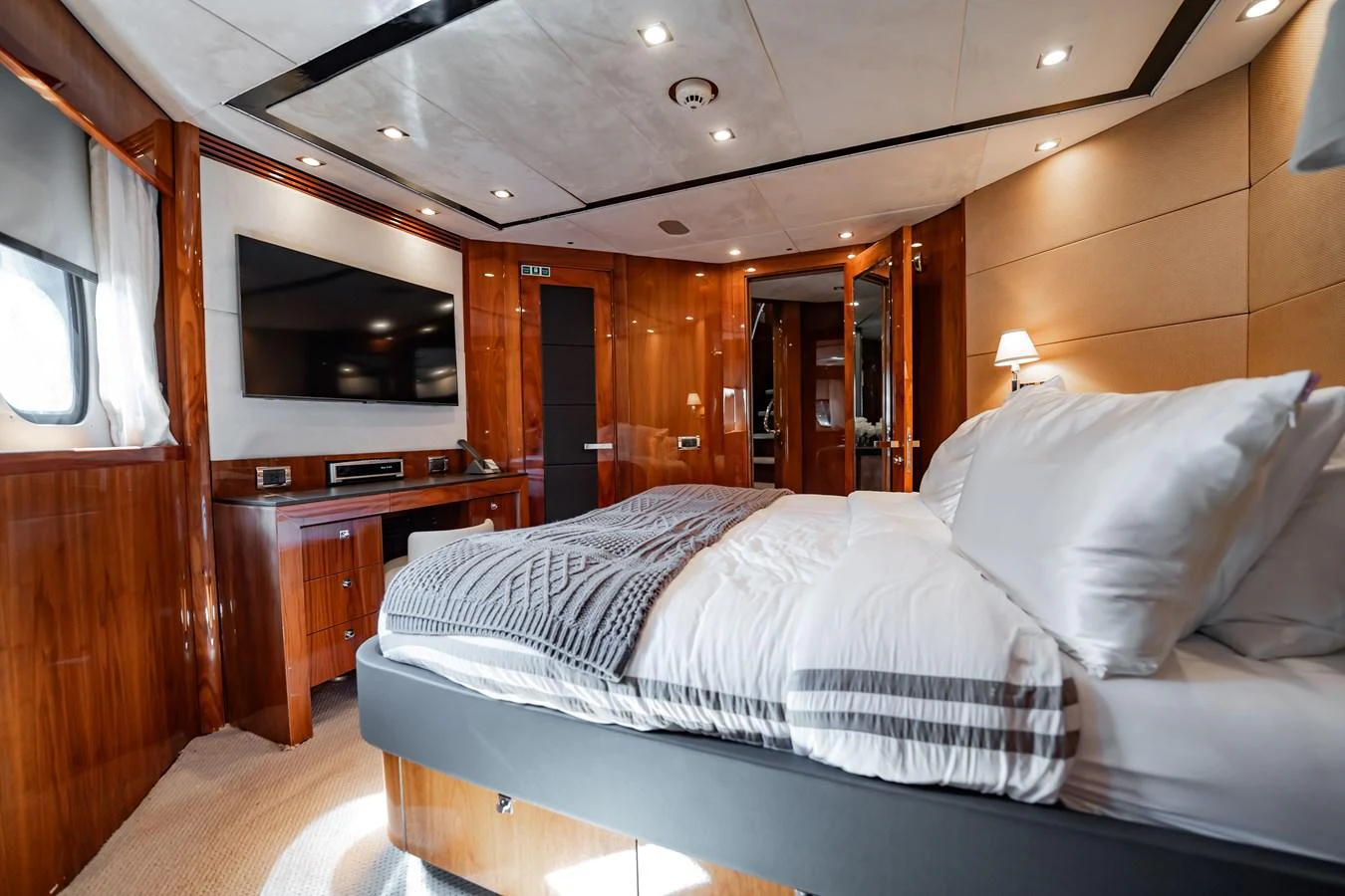 The stateroom features a luxurious bed with plush bedding and elegant wood finishes. aboard BLUE Yacht for Sale